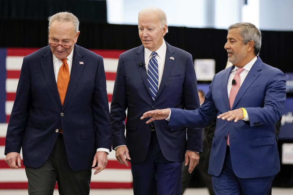 President Joe Biden and Senate Majority Leader Chuck Schumer of N.Y., left, listen as Sanjay Mehrotra, CEO of Micron Technology, right, speaks during a tour of Micron Pavilion at Onondaga Community College in Syracuse, N.Y., Thursday, Oct. 27, 2022. (AP Photo/Manuel Balce Ceneta)