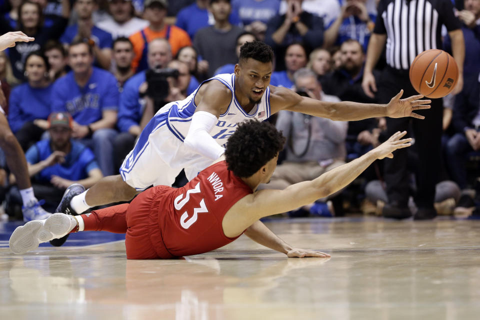 Duke forward Javin DeLaurier and Louisville forward Jordan Nwora (33) go to the floor while chasing the ball during the second half of an NCAA college basketball game in Durham, N.C., Saturday, Jan. 18, 2020. Louisville won 79-73. (AP Photo/Gerry Broome)