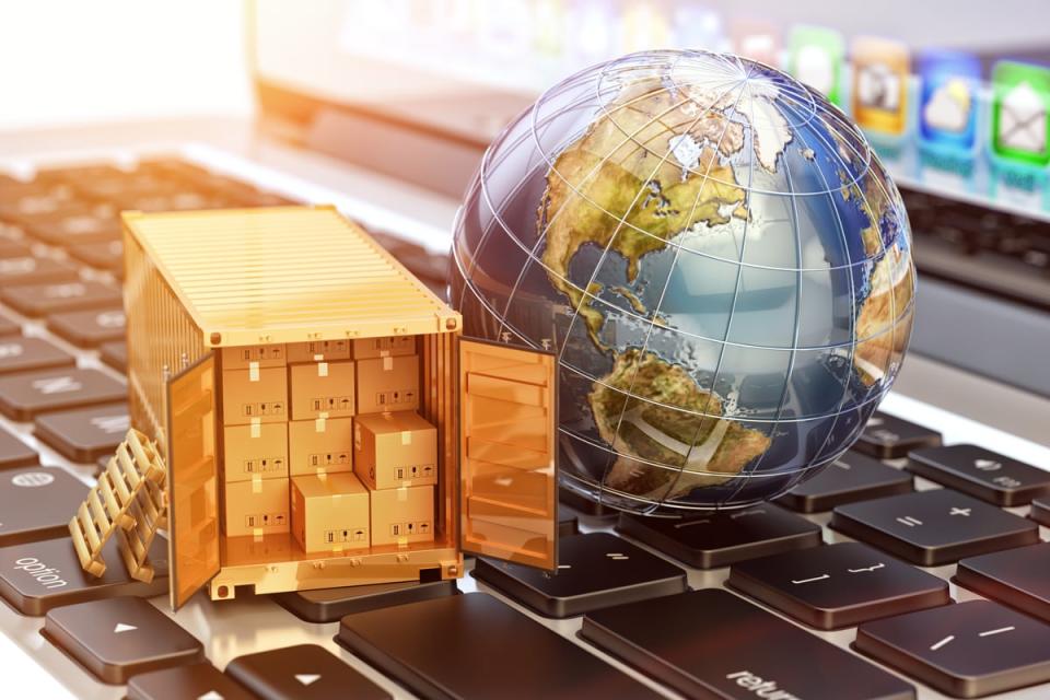 Rendering of a globe next to a shipping container with boxes inside, both sitting on a computer keyboard.