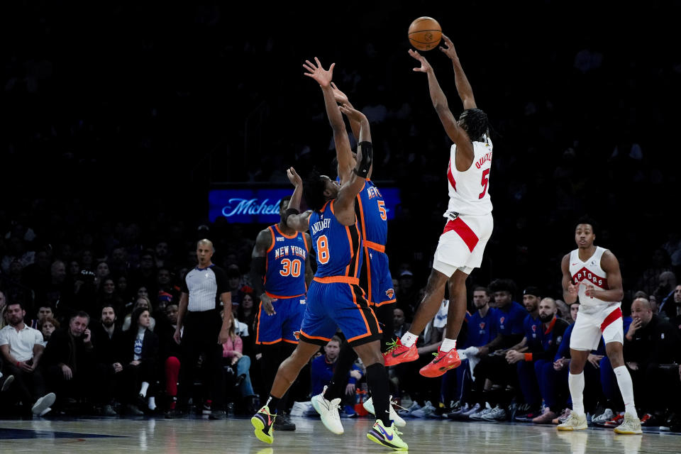 Toronto Raptors guard Immanuel Quickley (5) passes the ball over New York Knicks forward Precious Achiuwa (5) and forward OG Anunoby (8) during the first half of an NBA basketball game in New York, Saturday, Jan. 20, 2024. (AP Photo/Peter K. Afriyie)