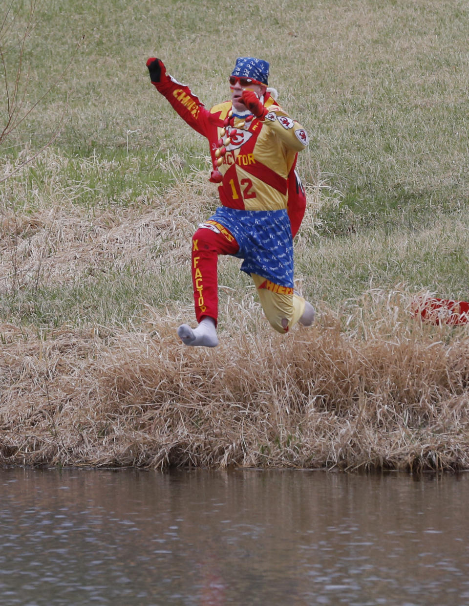 Kansas City Chiefs fan Ty Rowton, known as XFactor, takes a Plunge for Landon in a farm pond near Bonner Springs, Kan., Friday, April 4, 2014. A 5-month-old boy's battle with cancer has inspired hundreds to jump into cold bodies of water, from a local golf course pond to the Gulf of Mexico and even the Potomac River in Washington, D.C. (AP Photo/Orlin Wagner)