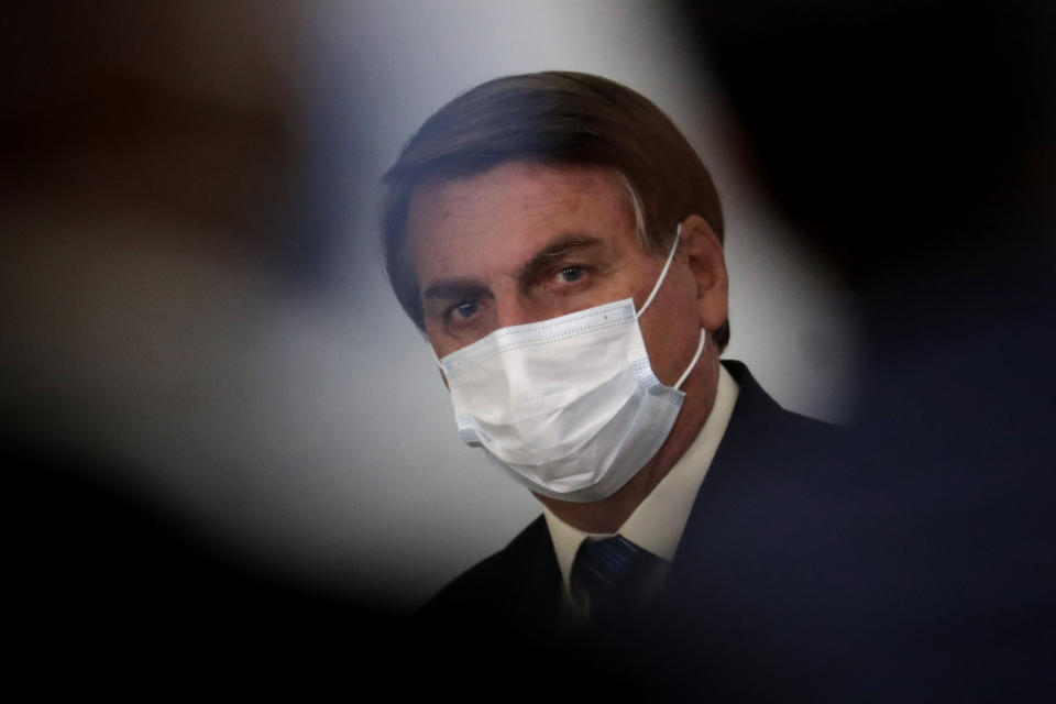 Brazil's President Jair Bolsonaro wearing a mask attends a ceremony about the extension of emergency aid to help the poor population affected by the COVID-19 pandemic, at the Planalto Presidential Palace, in Brasilia, Brazil, Tuesday, Sept. 1, 2020. (AP Photo/Eraldo Peres)