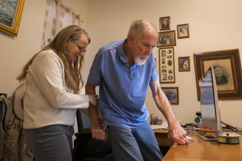 SPARKS, NEVADA, NOVEMBER 20, 2023 - Tammie Mund helps her husband Gary Mund get up from his office chair in their home in Sparks, Nevada on Monday November 20, 2023.. Gary has Parkinson's Disease as a result of exposure to the herbicide Paraquat, and is part of a lawsuit against it's manufacturer and hopes to see it banned. (Monique Sady / For The Times)