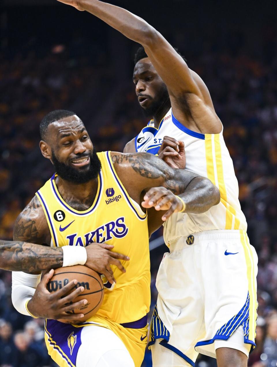 LeBron James drives against a Warriors forward.