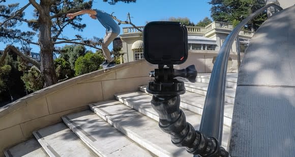 A GoPro camera recording a skateboarder doing tricks down an outdoor flight of stairs.