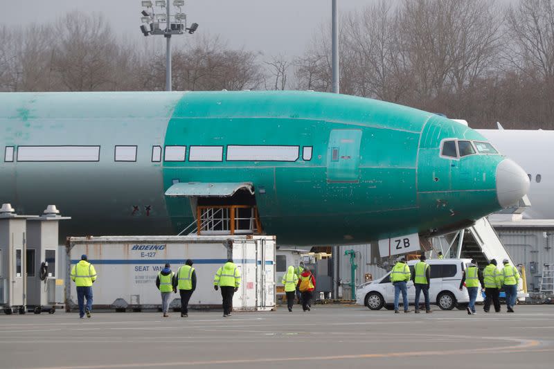 FILE PHOTO: Boeing employees walk near a partially finished Boeing 777X airplane at the company's plant in Everett