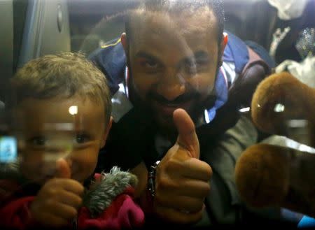 Migrants arriving from Hegyeshalom, Hungary, gesture as they sit in a train at the railway station in Vienna, Austria, September 5, 2015. REUTERS/Leonhard Foeger