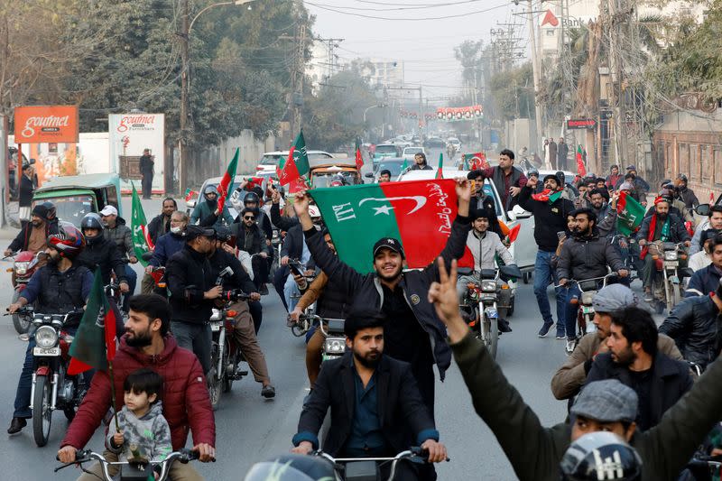 Supporters of former Prime Minister Imran Khan wave flags during a rally ahead of the general elections in Lahore