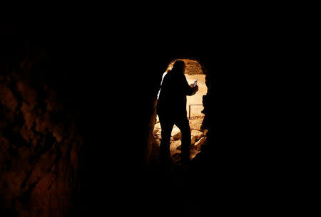 A man takes pictures of artefacts and archaeological pieces in a tunnel network running under the Mosque of Prophet Jonah, Nabi Yunus in Arabic, in eastern Mosul, Iraq March 9, 2017. REUTERS/Suhaib Salem