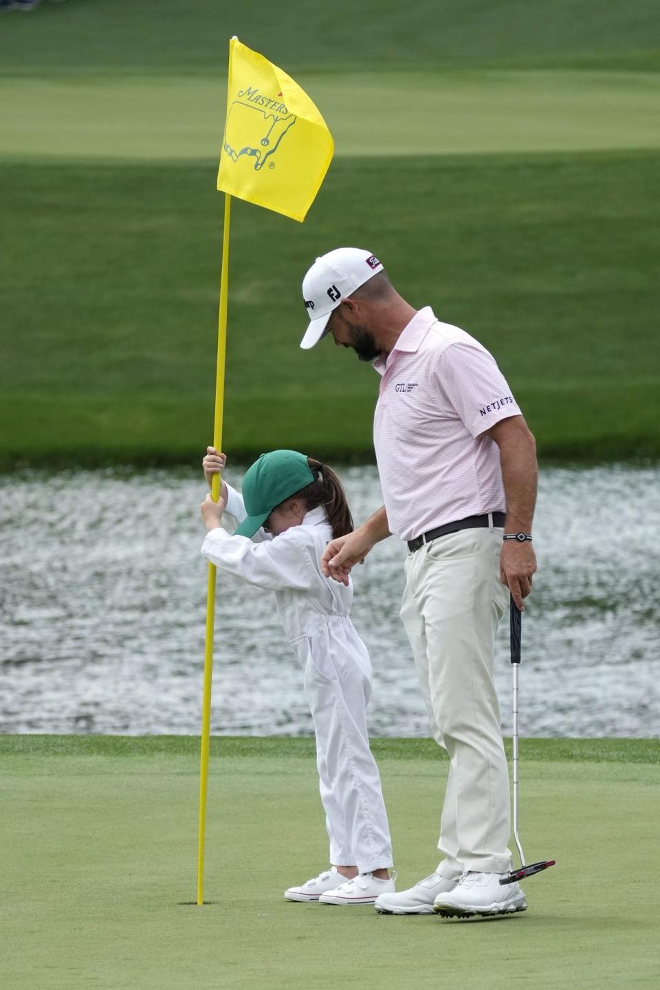 Apr 5, 2023; Augusta, Georgia, USA; Brian Harman looks on as daughter Cooper Marie places the pin in the cup during the Par 3 Contest at The Masters golf tournament at Augusta National Golf Club. Mandatory Credit: Michael Madrid-USA TODAY Network