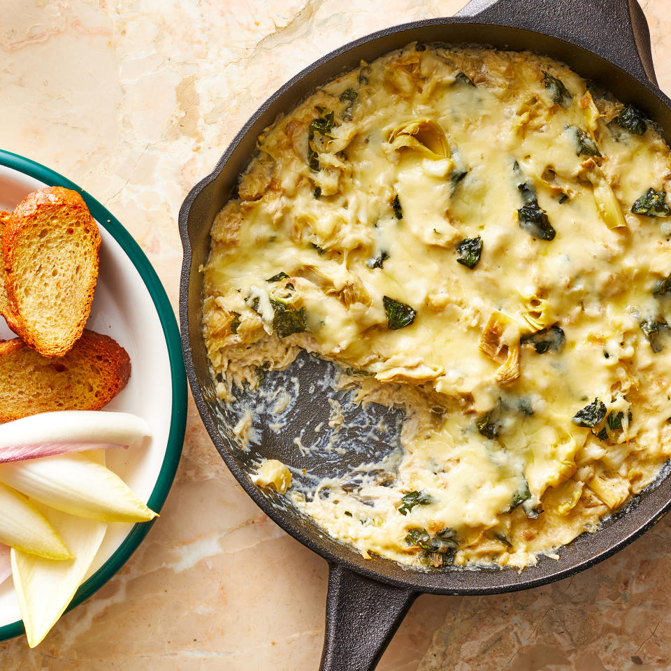 <p>This hot crab-artichoke dip is baked and served right in the skillet. Tangy artichoke hearts team up with sweet crab bound by mild cream cheese and gooey mozzarella. Kale adds color and texture to this party favorite. <a href="https://www.eatingwell.com/recipe/7923678/crab-artichoke-dip/" rel="nofollow noopener" target="_blank" data-ylk="slk:View Recipe" class="link ">View Recipe</a></p>