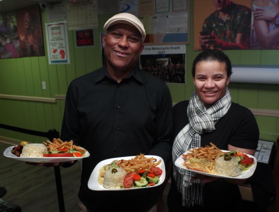 Manny "Preto" Dasilva and his wife, Isabel Ribeiro, present samples of house dishes at Preto's Island Cuisine in Brockton on Tuesday, Dec. 28, 2021.