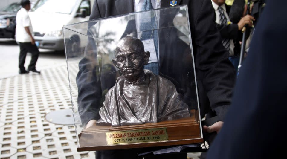 A member of the US government staff carries a bust of Mahatma Gandhi presented as a gift to President Barack Obama during his trip in New Delhi on Nov. 8, 2010. Photo: Reuters/Jason Reed