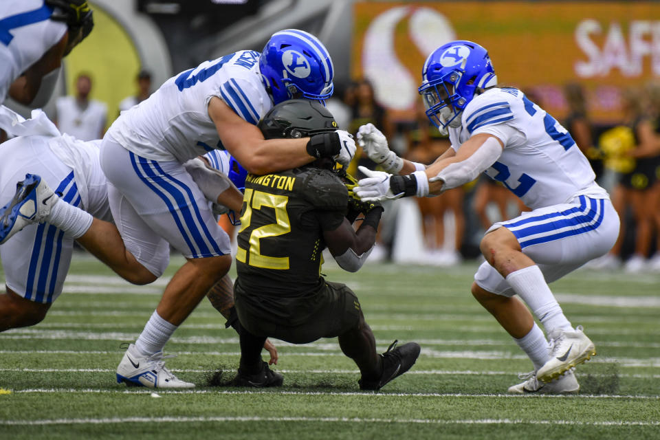 Oregon running back Noah Whittington is stopped by BYU defensive lineman Fisher Jackson and defensive back Ammon Hannemann during the second half of an NCAA college football game, Saturday, Sept. 17, 2022, in Eugene, Ore. (AP Photo/Andy Nelson)