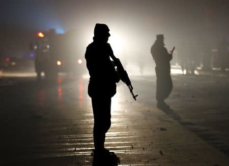 Afghan policemen stand guard at the site of a suicide bomb attack in an area near the Russian embassy in Kabul, Afghanistan January 20, 2016. REUTERS/Omar Sobhani