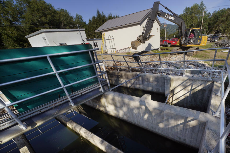 A worker uses an excavator to clear debris away from the wastewater treatment plant, Wednesday, Aug. 2, 2023, in Ludlow, Vt. Across the U.S., municipal water systems and sewage treatment plants are at increasing risk of damage from floods and sea-level rise brought on in part or even wholly by climate change. The storm that walloped Ludlow especially hard, damaging the picturesque ski town’s system for cleaning up sewage before it’s discharged into the Williams River. (AP Photo/Charles Krupa)