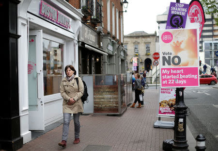 A woman walks past a pro-life poster in the city centre of Dublin, Ireland, May 22, 2018. REUTERS/Max Rossi