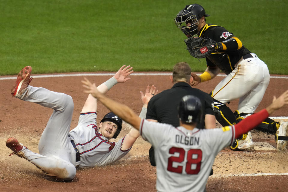 Atlanta Braves' Sean Murphy, left, scores under a tag-attempt by Pittsburgh Pirates catcher Endy Rodriguez, top right, the second of two runs driven in on a single by Marcell Ozuna off Pittsburgh Pirates starting pitcher Osvaldo Bido, during the fourth inning of a baseball game in Pittsburgh, Monday, Aug. 7, 2023. (AP Photo/Gene J. Puskar)