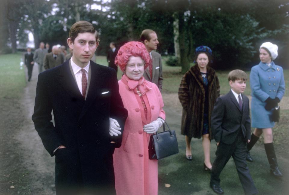 1969:  Prince Charles arm in arm with Queen Elizabeth the Queen Mother (1900 - 2002) at Sandringham. Prince Philip the Duke of Edinburgh, Princess Margaret, Princess Anne and Prince Andrew all walk behind them.  (Photo by Fox Photos/Getty Images)