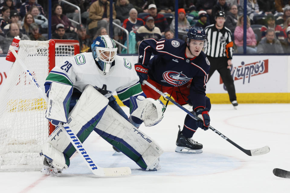 Vancouver Canucks goalie Casey DeSmith, left, protects the net as Columbus Blue Jackets' Dmitri Voronkov looks for the puck during the second period of an NHL hockey game Monday, Jan. 15, 2024, in Columbus, Ohio. (AP Photo/Jay LaPrete)