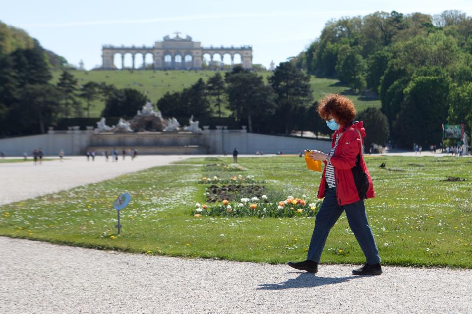 A woman wearing a protective face mask walks in the garden of Schoenbrunn Palace in Vienna on April 26, 2020, amid the novel coronavirus COVID-19 pandemic. - In Austria, since the outbreak of the novel coronavirus COVID-19, wearing a mask in shops or public transport has been mandatory in public spaces a minimum distance of 1 meter from people not living in the same household. (Photo by ALEX HALADA / AFP) (Photo by ALEX HALADA/AFP via Getty Images)