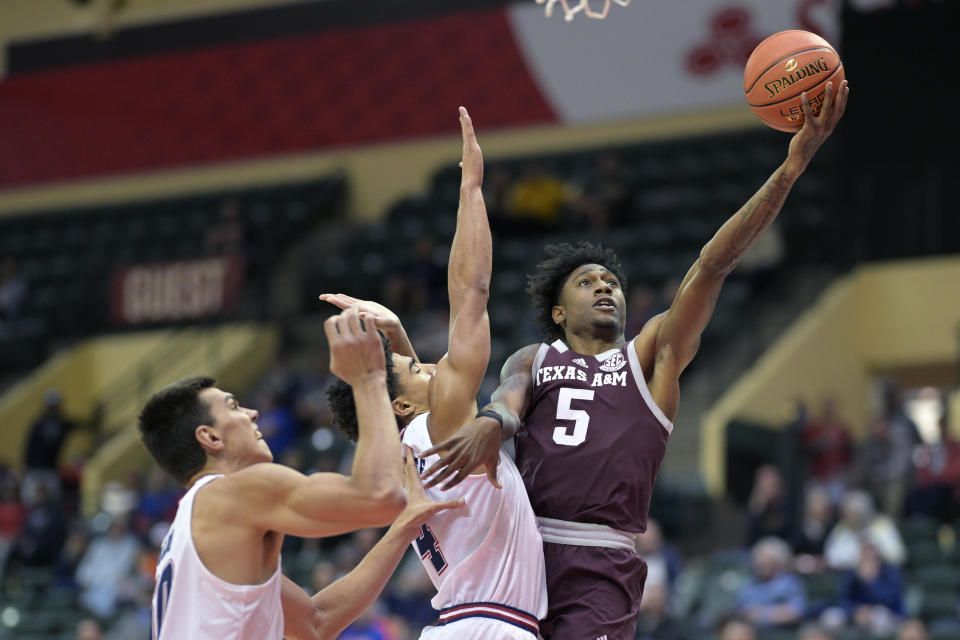 Texas A&M guard Eli Lawrence (5) goes up for a shot while defended by Florida Atlantic guard Bryan Greenlee (4) and center Vladislav Goldin, left, during the first half of an NCAA college basketball game, Friday, Nov. 24, 2023, in Kissimmee, Fla. (AP Photo/Phelan M. Ebenhack)