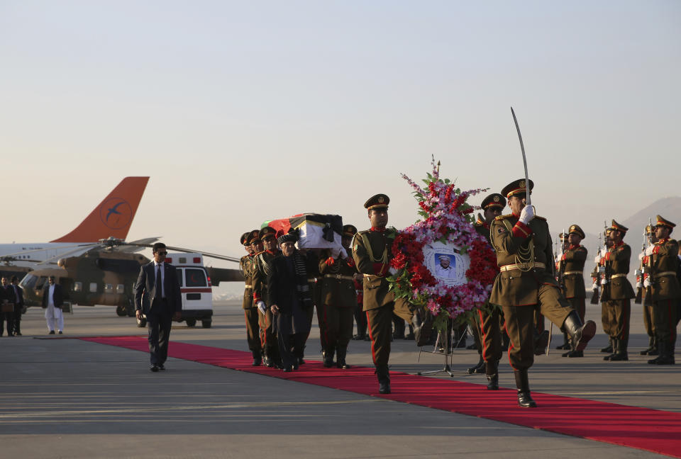 Afghan President Ashraf Ghani and Afghan honor guards carry the coffin of Japanese physician Tetsu Nakamura during a ceremony before transporting his body to his homeland, at the Hamid Karzai International Airport in Kabul, Afghanistan, Saturday, Dec. 7, 2019. Nakamura was killed earlier this week in a roadside shooting in eastern Afghanistan. (AP Photo/Rahmat Gul)