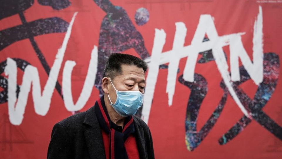 A man wears a mask while walking in the street on 22 January 2020 in Wuhan