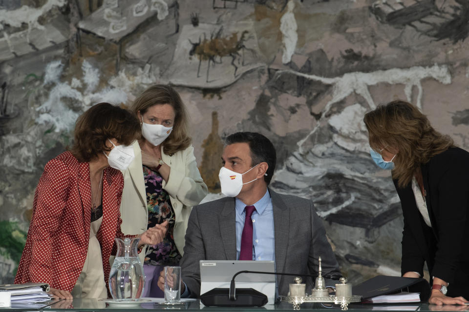 In this photo provided by the Spanish Government in Madrid, Spain's Prime Minister Pedro Sanchez, centre, speaks with three of his ministers, during a cabinet meeting at the Moncloa Palace in Madrid, Tuesday June 22, 2021. The Spanish Cabinet met on Tuesday to issue pardons for nine imprisoned Catalans who spearheaded the 2017 effort to set an independent republic in the affluent northeastern region, a move that Prime Minister Pedro Sanchez says is needed to bring reconciliation. (Borja Puig de la Bellacasa/Spanish Government via AP)