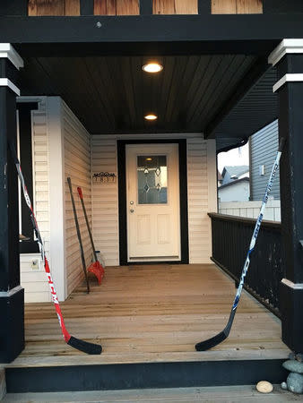 Hockey sticks are seen on a porch in tribute to the 15 youth players and personnel killed in a bus crash, in Edmonton, Alberta, Canada April 8, 2018 in this picture obtained from social media on April 9, 2018. TWITTER/@OILFANCHADDO via REUTERS