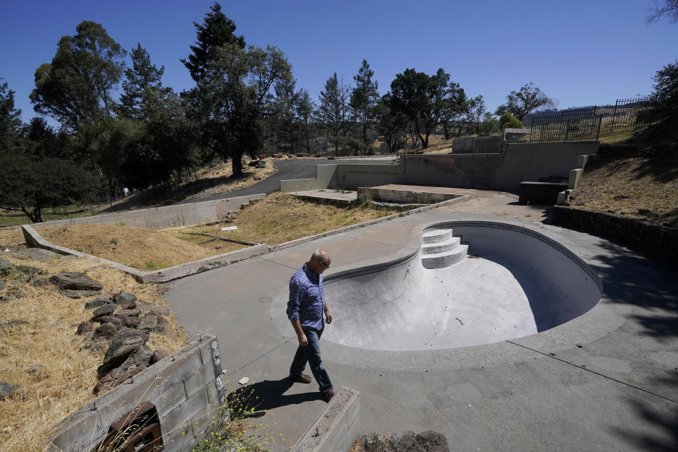 Will Abrams walks on the lot of his family home that was destroyed by wildfires in 2017 while interviewed in Santa Rosa, Calif., Thursday, June 24, 2021. “I have been really disappointed," Abrams said. “The bankruptcy was sold as something that was going to hold PG&E to account, and it was not. Bankruptcy is not a process to reorganize. It is a process to divide up the dollars." (AP Photo/Jeff Chiu)