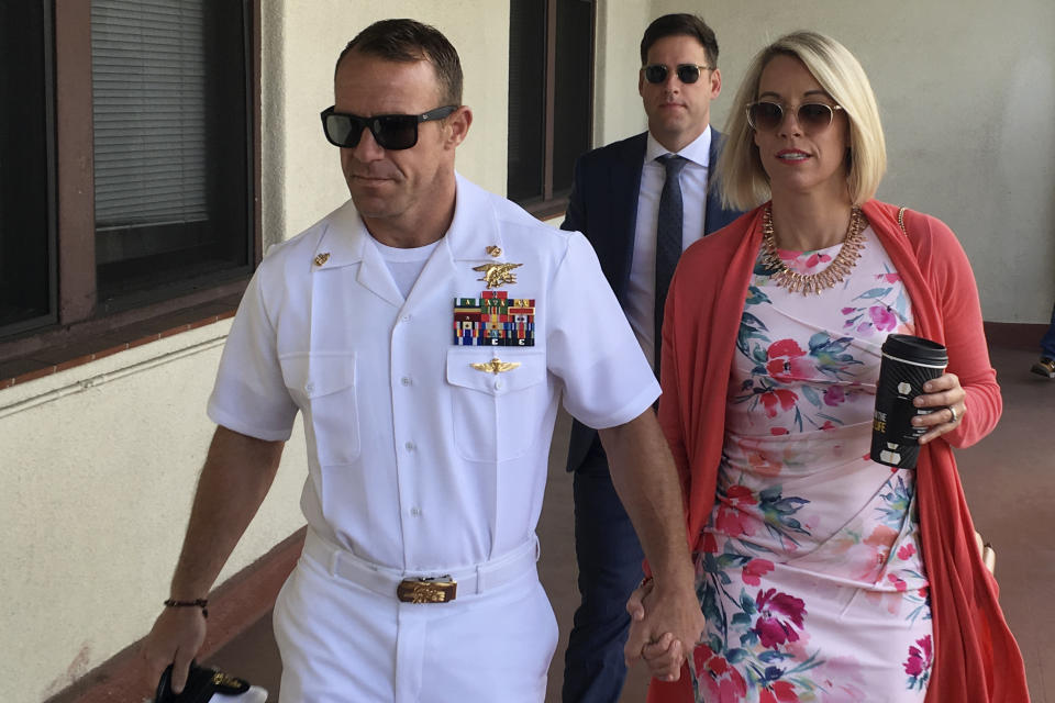 Navy Special Operations Chief Edward Gallagher, left, walks with his wife, Andrea Gallagher as they arrive to military court on Naval Base San Diego, Monday, July 1, 2019, in San Diego. The trial continued Monday in the court-martial of the decorated Navy SEAL, who is accused of stabbing to death a wounded teenage Islamic State prisoner and wounding two civilians in Iraq in 2017. He has pleaded not guilty to murder and attempted murder, charges that carry a potential life sentence. (AP Photo/Julie Watson)