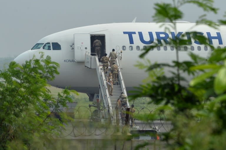 Security officials with a sniffer dog walk onto a Turkish Airlines aircraft as it sits on the tarmac at Indira Gandhi International Airport in New Delhi on July 7, 2015