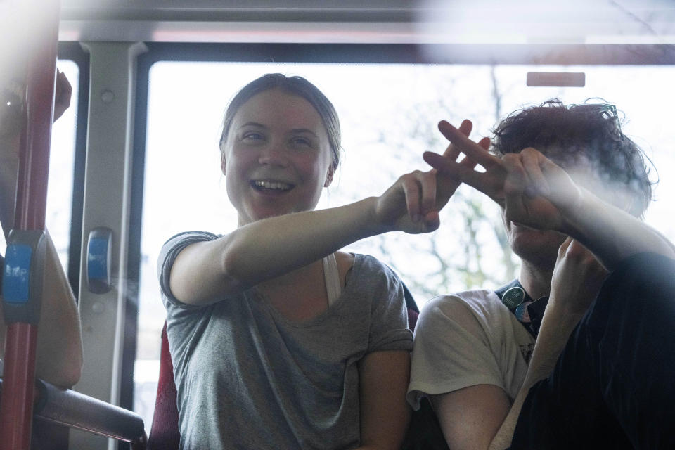 Climate activist Greta Thunberg flashes a V-sign after being detained and driven off in a bus after joining protestors who blocked a road during a climate protest by Extinction Rebellion and other activists near the Dutch parliament in The Hague, Netherlands, Saturday, April 6, 2024. (AP Photo/Peter Dejong)