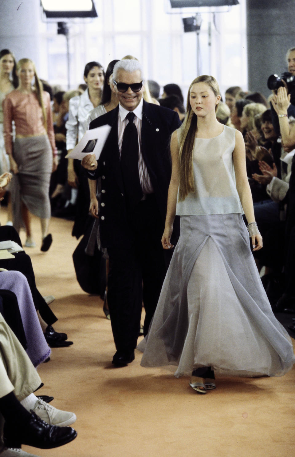 Designer Karl Lagerfeld walks the runway at the finale of the show, with model Devon Aoki