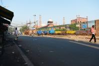 People walk through a partially empty road during a one-day Janata (civil) curfew imposed amid concerns over the spread of the COVID-19 novel coronavirus, near Jama Masjid mosque in the old quarters of New Delhi on March 22, 2020. (Photo by Sajjad HUSSAIN / AFP) (Photo by SAJJAD HUSSAIN/AFP via Getty Images)