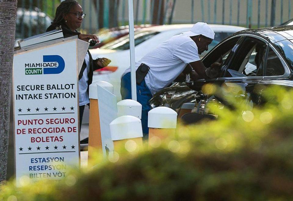 Trabajadores electorales ayudan a una automovilista a emitir su voto. El lunes 24 de octubre de 2022, un habitante de Miami emite su voto durante el primer día de votación anticipada en el Condado Miami-Dade en la Lemon City Library en Miami, Florida.