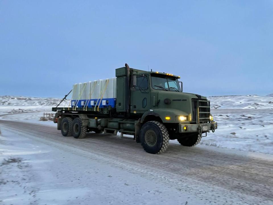 Task Force Iqaluit members are preparing to use military truck-mounted water containers to transport river water to the facility for purifying. (David Gunn/CBC News - image credit)