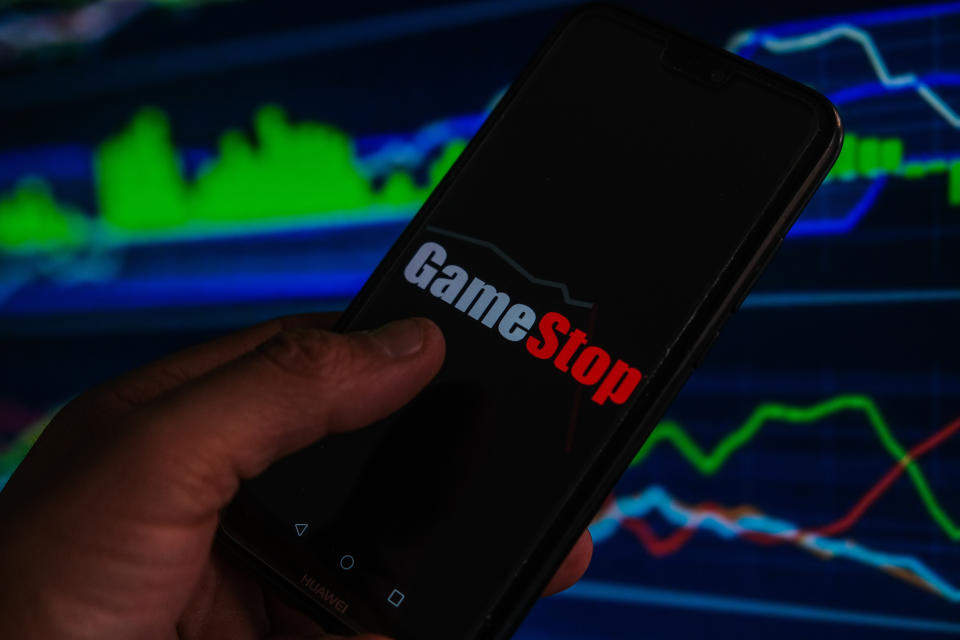 In this photo illustration a Game Stop logo is displayed on a smartphone with stock market percentages in the background. (Photo Illustration by Omar Marques/SOPA Images/LightRocket via Getty Images)