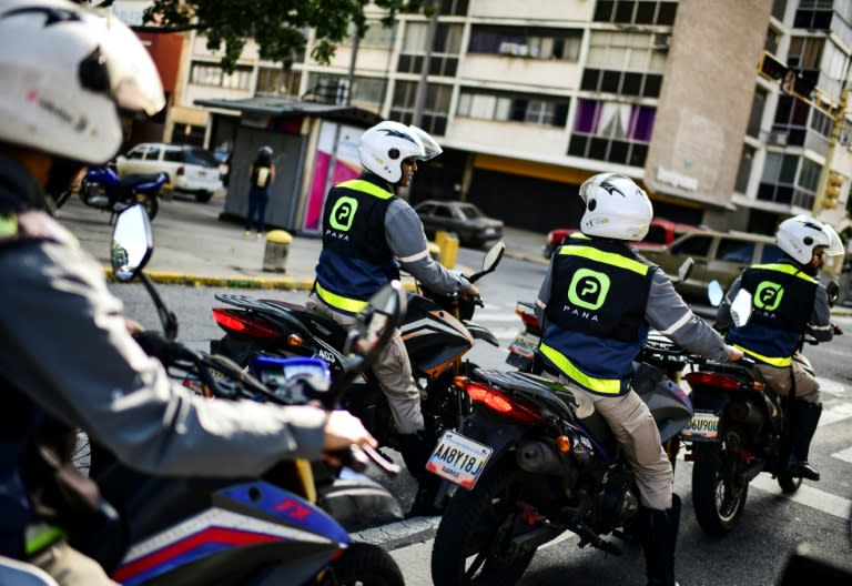 Employees of Venezuelan app "Pana" (Buddy) drive their motorcycles in Caracas, ready to speed to the rescue of motorists who push the "Pana" panic button on their phones