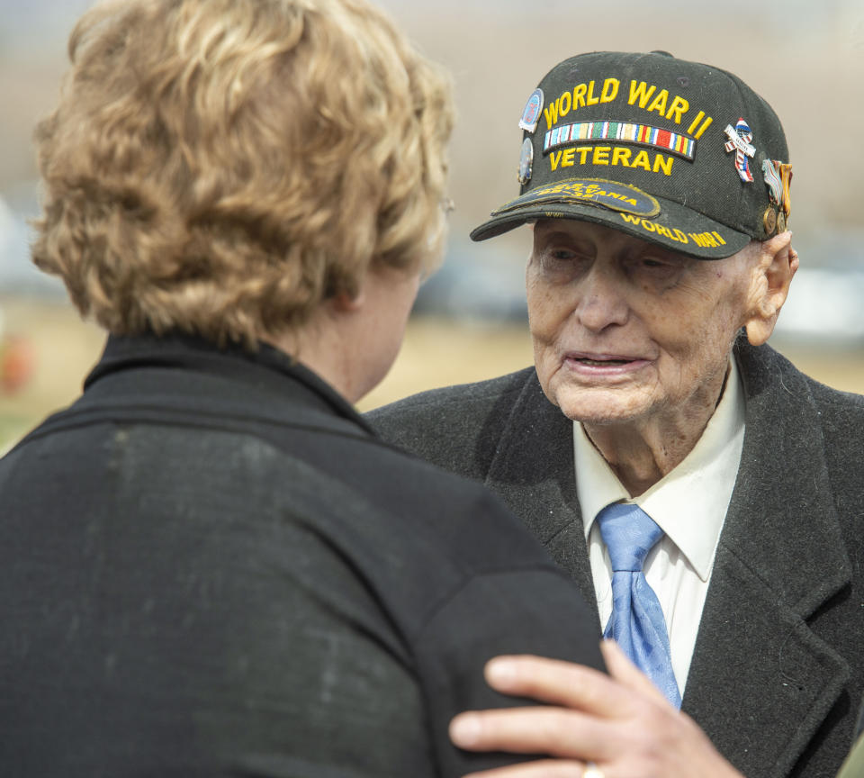 Roy Solt, 92, who was in the Navy in World War II, visits with Mary Ann Turner, the daughter of 2nd Lt. Lynn W. Hadfield, at Veterans Memorial Park, in Bluffdale, Utah, Thursday, March 21, 2019. The Salt Lake City Tribune reported Thursday that Army Air Forces 2nd Lt. Lynn W. Hadfield's remains, returned from Germany, were buried 74 years to the day of Hadfield's crash during a bomber plane run from France to Germany just months before the war's end. (Rick Egan/The Salt Lake Tribune via AP)