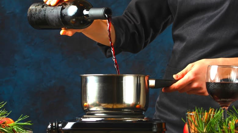 Chef pouring red wine into pot