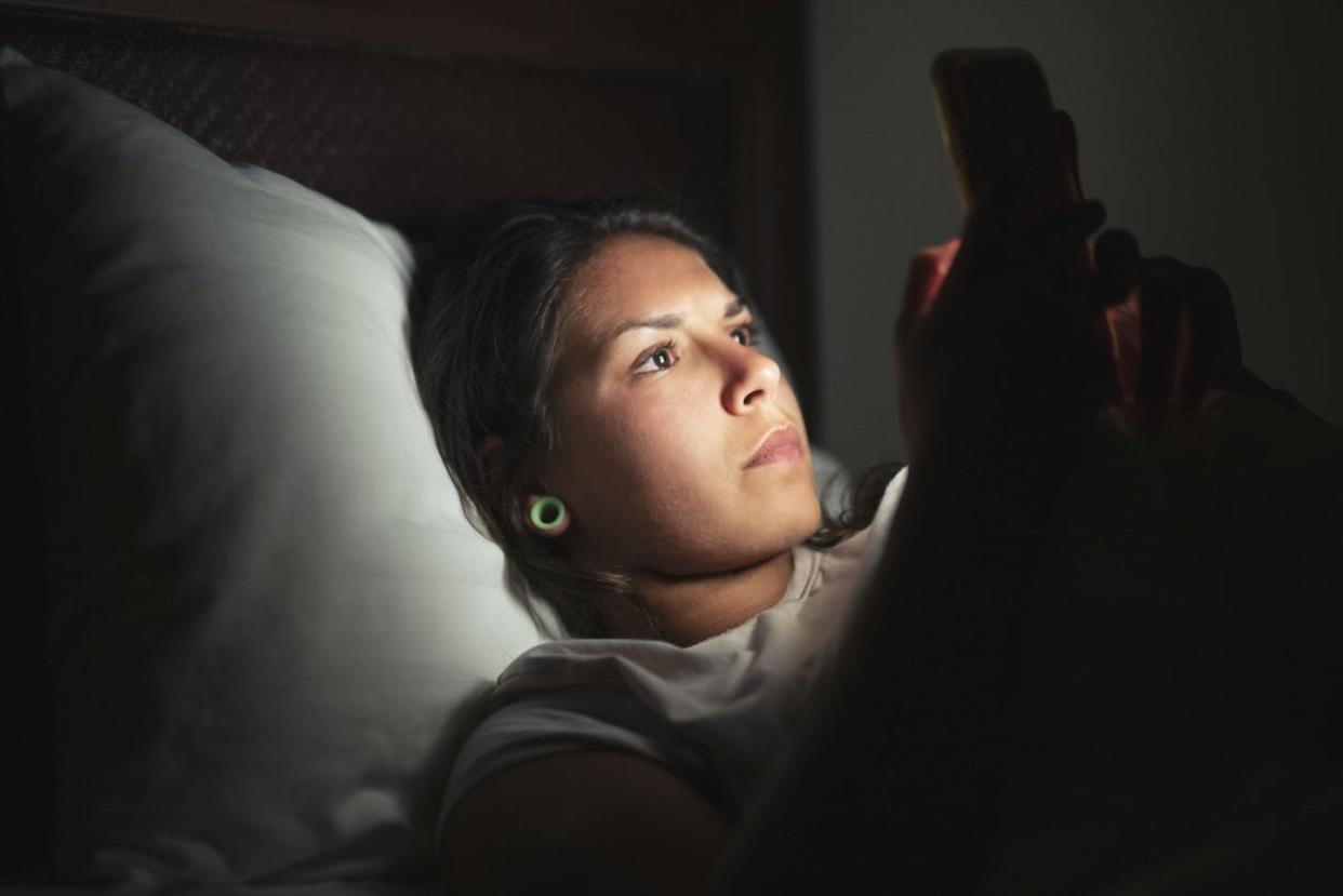 Doomscrolling is not going to help. <a href="https://www.gettyimages.com/detail/photo/young-woman-laying-in-bed-and-using-smart-phone-royalty-free-image/1173571335" rel="nofollow noopener" target="_blank" data-ylk="slk:ArtistGNDphotography/E+ via Getty Images;elm:context_link;itc:0;sec:content-canvas" class="link ">ArtistGNDphotography/E+ via Getty Images</a>