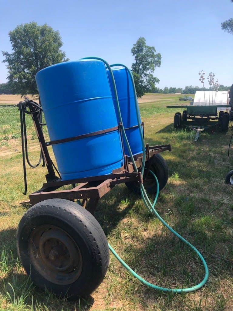 Two tanks of water sit, ready to be pulled by a Kubota Ranger around VanAntwerp Farm on June 2, 2023. Attached to the tanks are hoses, which Lance and Thaddeus Goecker use to water in their plants when there hasn't been sufficient rain.