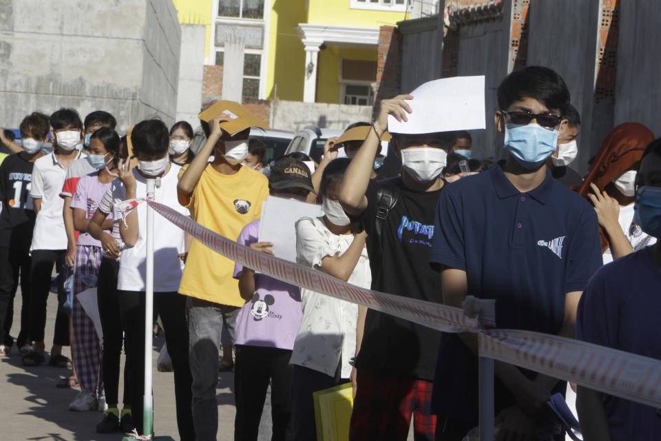 Young people line up for receiving shot of the Sinovac's COVID-19 vaccine at the Phnom Penh Thmey Health Center, during a campaign in Phnom Penh, Cambodia, Sunday, Aug. 1, 2021. Cambodia on Sunday began its inoculation campaign against the COVID-19 virus to the young people aged 12-17. (AP Photo/Heng Sinith)