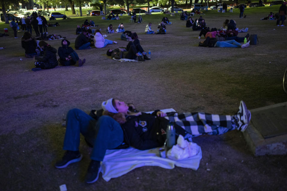 People gather around the planetarium to watch a lunar eclipse during the first blood moon of the year in Buenos Aires, Argentina, Monday, May 16, 2022. (AP Photo/Rodrigo Abd)