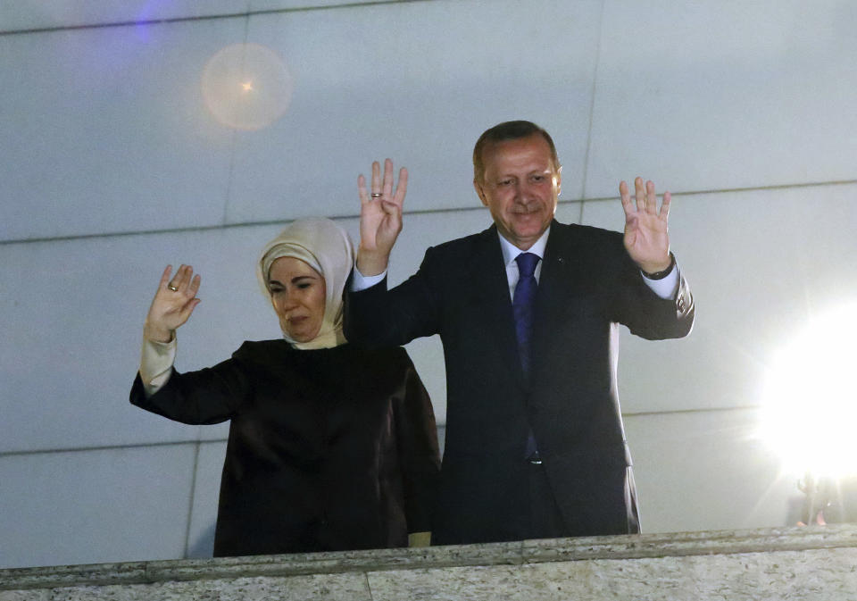 Turkey's Prime Minister Recep Tayyip Erdogan and his wife Emine Erdogan wave to supporters from the balcony of his ruling party headquarters in Ankara, Turkey, early Monday, March 31, 2014. Erdogan on Sunday hailed what appeared to be a clear victory in local elections, providing a boost that could help him emerge from a spate of recent troubles. Erdogan was not on the ballots in the countrywide polls, but with about half of votes counted, Turkish newswires suggested that his party was significantly outstripping its results in the last local elections of 2009 and roundly beating the main opposition party. (AP Photo)