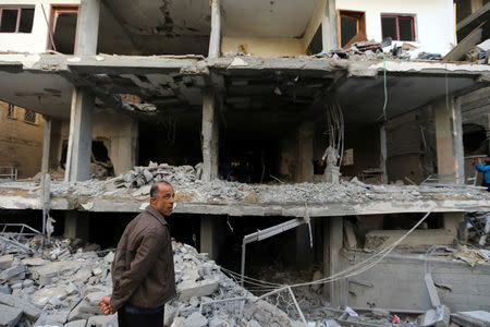 A Palestinian man stands in front of the remains of building that was destroyed by an Israeli air strike, in the southern Gaza Strip May 5, 2019. REUTERS/Ibraheem Abu Mustafa