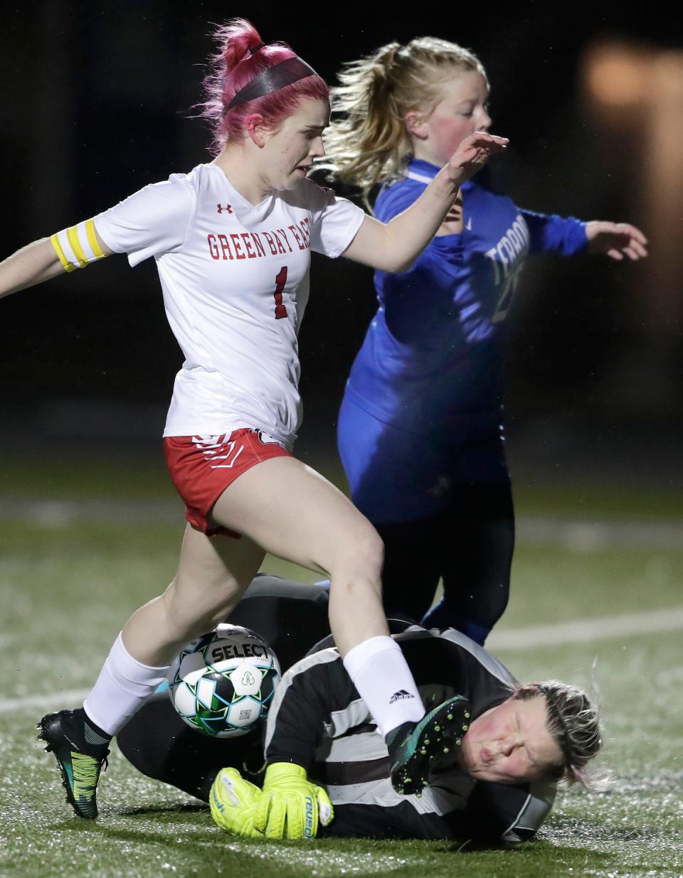 Appleton West goalkeeper AJ Jazdzewski stops a shot by Green Bay East's Ellana Gallegos as West's Gwen Konkle defends during their soccer game Thursday at West.