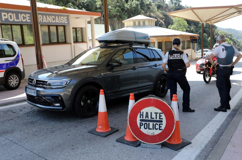 French police officers control vehicles at the border point with Spain, in Le Perthus, southern France on July 25, 2020. - French Prime Minister on July 24 said that while France's border with Spain would remain open for now despite a surge in cases in Catalonia, French people should avoid going there until the health situation improves. (Photo by RAYMOND ROIG / AFP) (Photo by RAYMOND ROIG/AFP via Getty Images)